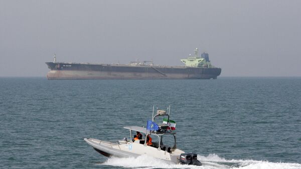 In this July 2, 2012 file photo, an Iranian Revolutionary Guard speedboat moves in the Persian Gulf while an oil tanker is seen in background - Sputnik International