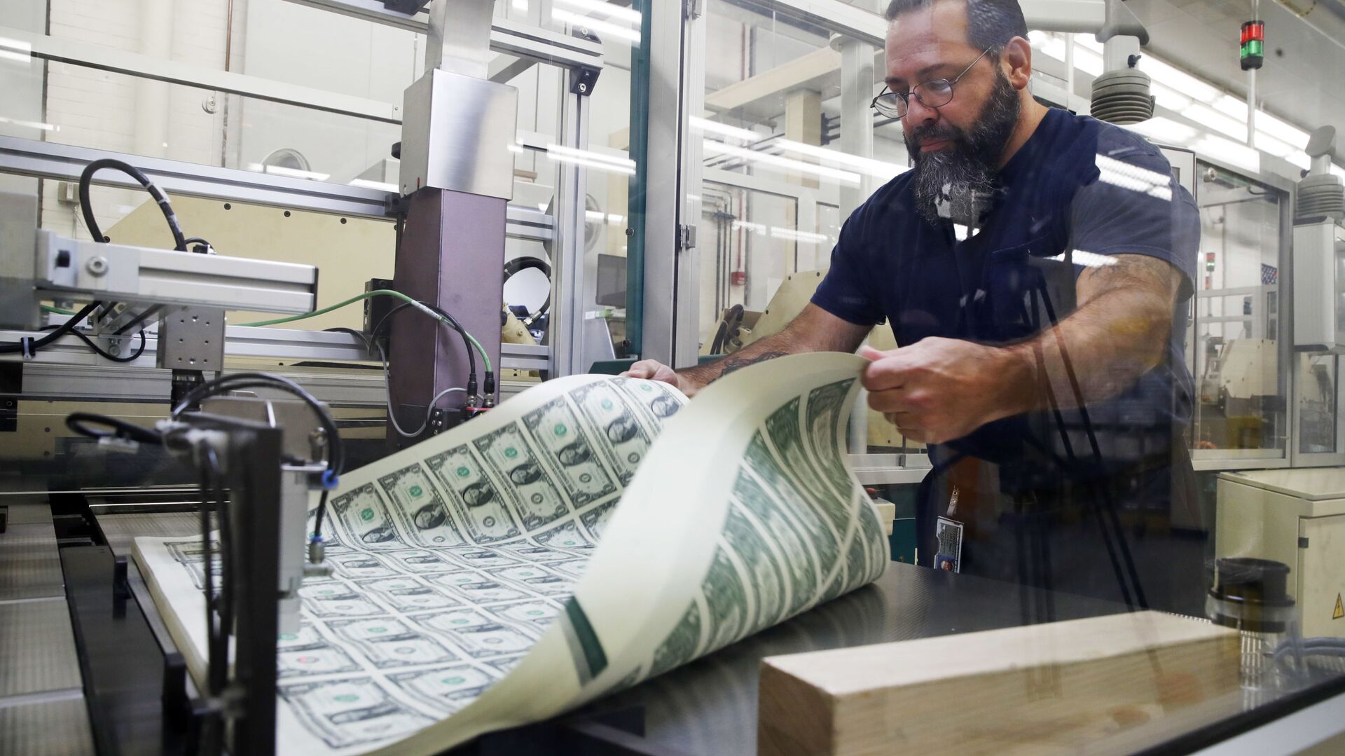FILE- In this Nov. 15, 2017, file photo, a worker aerates printed sheets of dollar bills at the Bureau of Engraving and Printing in Washington.  - Sputnik International, 1920, 24.08.2023