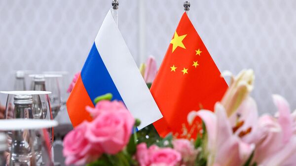 Russian and Chinese flags at the negotiating table during the meeting between Russian Foreign Minister Sergey Lavrov and his Chinese counterpart Qin Gang at the G20 summit in India, March 2, 2023. - Sputnik International