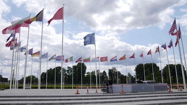 Two men do construction work around the flags at NATO headquarters in Brussels, Thursday, July 6, 2023.  - Sputnik International